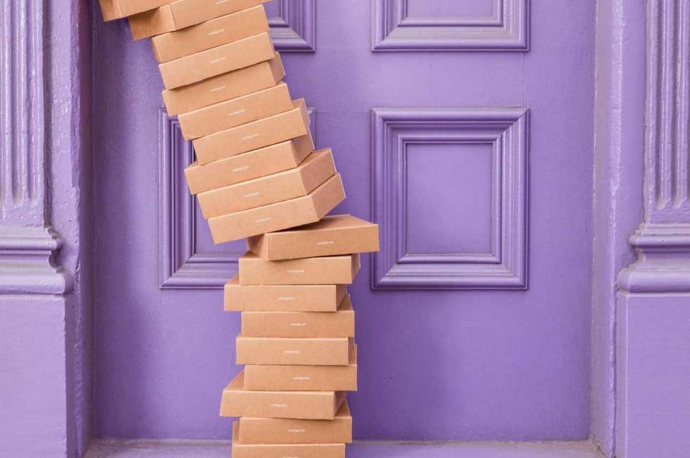 dimensional weight | stack of packages in front of a purple door
